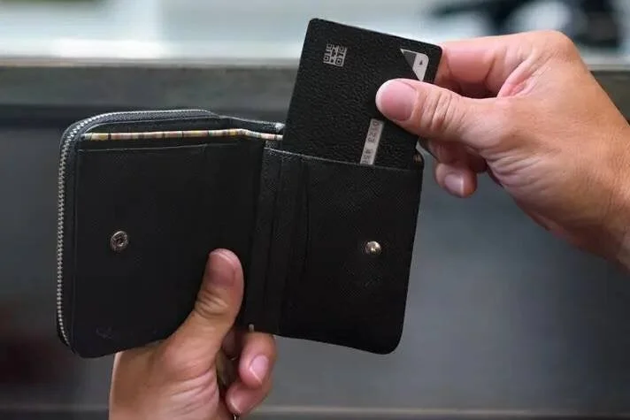黒い財布から黒いカードを取り出す、または収納している手元の様子